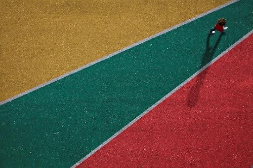 Aerial view of person walking on colorful athletic field